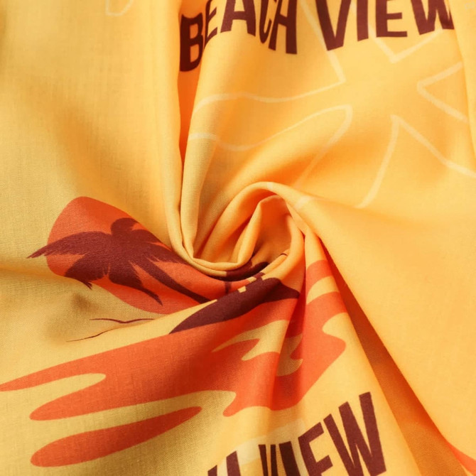 A yellow fabric featuring palm tree and beach-themed designs in red and brown tones. It has a logo present.