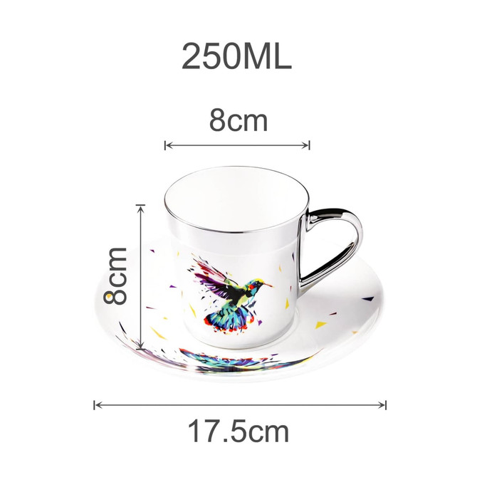 A ceramic coffee mug with a vibrant hummingbird design, silver handle, and matching saucer, measuring 250ML.