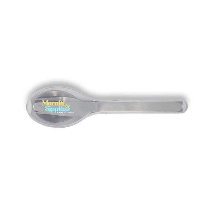 A silver spoon with a rounded end, featuring a logo on the handle.