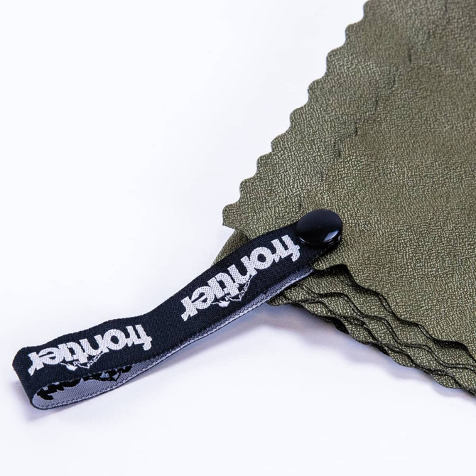 A green cooling towel with a black strap featuring a logo. The towel has a textured surface and is neatly folded.