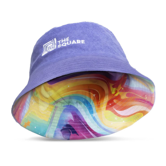 A purple reversible bucket hat featuring a vibrant, multicoloured tie-dye pattern on the inside and a logo.
