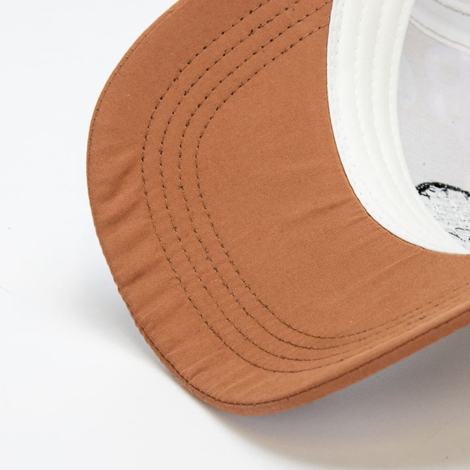 A brown cap with a white underside of the brim, featuring stitching details and an interior patch.