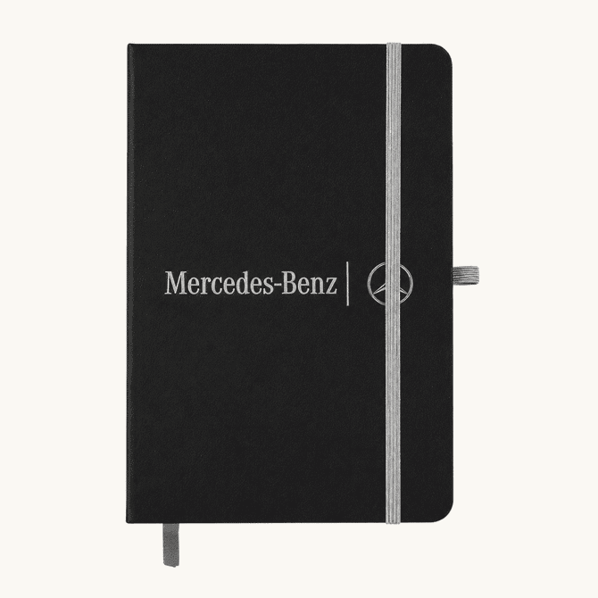 A black A5 notebook with an elastic closure and a logo on the front, featuring a grey band and bookmark.