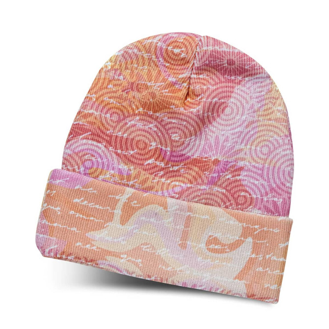 A full-colour beanie in pink and orange hues with a swirled pattern and a cuffed design. It has a logo.