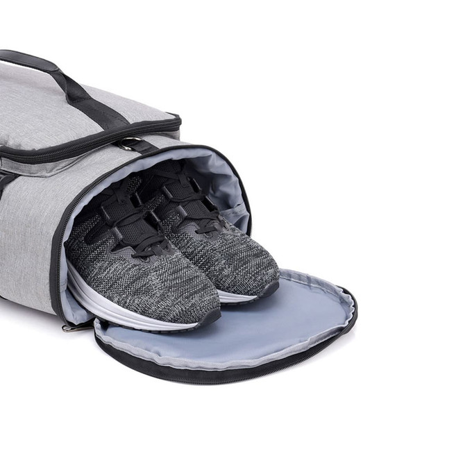 A grey convertible bucket backpack duffel bag with grey and black sports shoes inside, featuring a top opening.