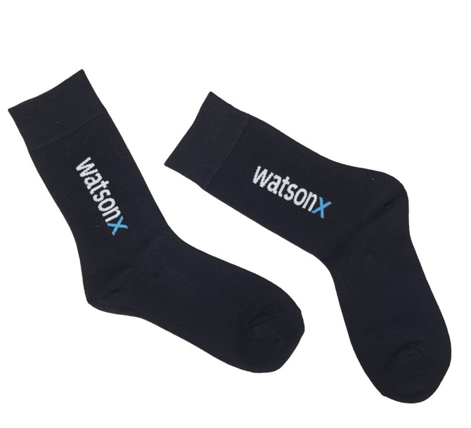 A pair of black socks featuring a logo, with a ribbed top and a smooth finish.
