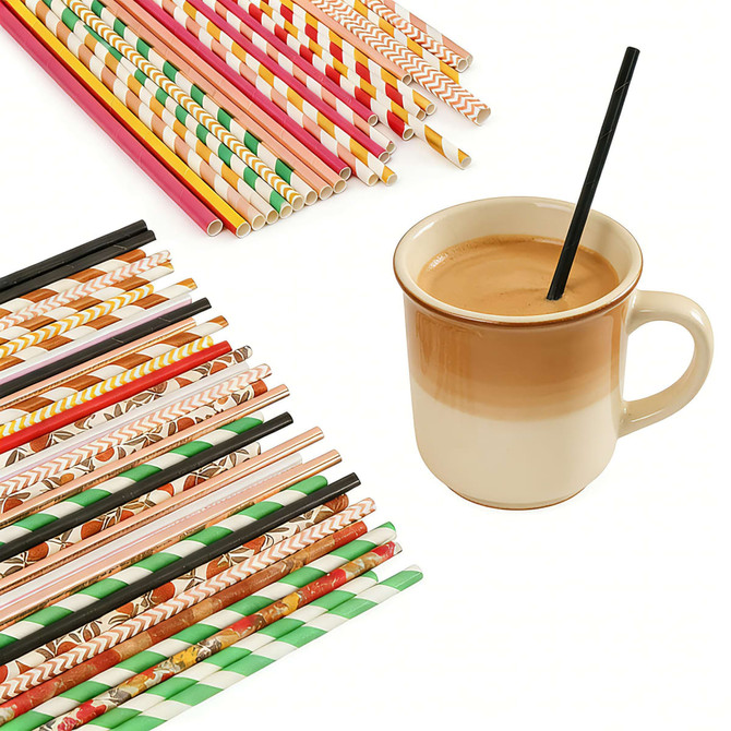 A variety of colourful paper straws in different patterns alongside a cup of coffee with a black straw.