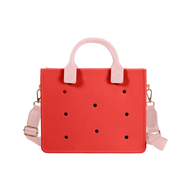 A red tote bag with pink handles and a removable shoulder strap, featuring decorative holes and a logo.