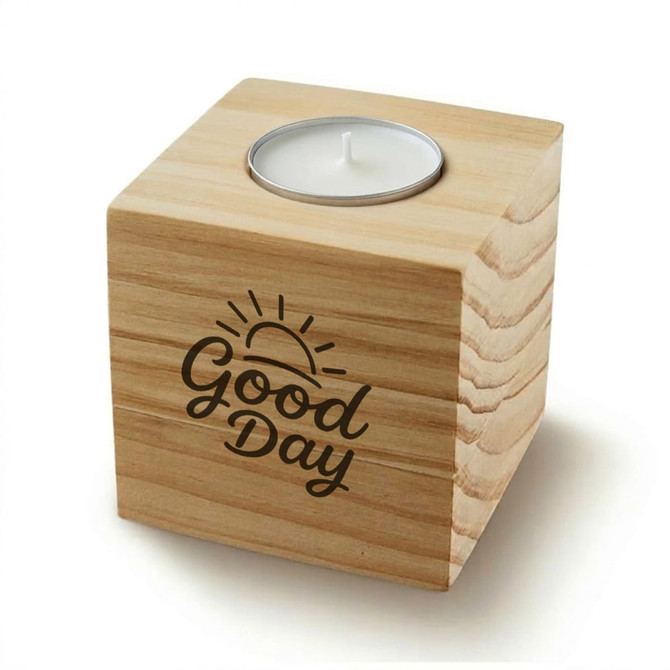 A wooden cube candle with a metal holder for a tealight, featuring a sun design and the words "Good Day".
