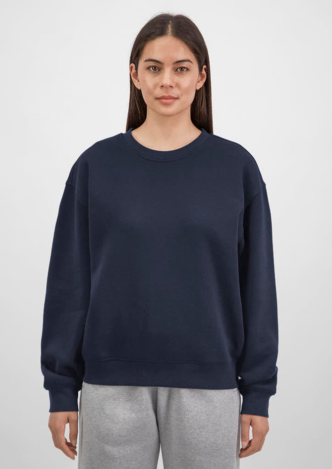 A navy crew sweatshirt for women featuring a relaxed fit, paired with grey sweatpants. It has a logo on the front.