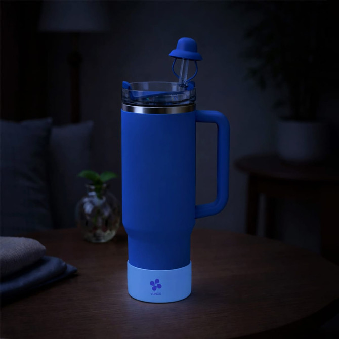 A drink bottle with a glow-in-the-dark silicone boot in blue, featuring a stainless steel top and a straw.