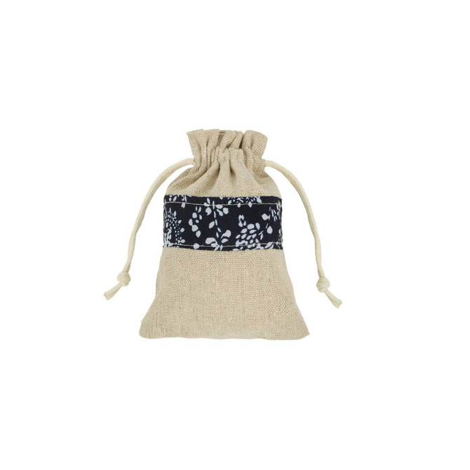 A cotton linen drawstring bag in natural and navy patchwork design with a decorative floral band.