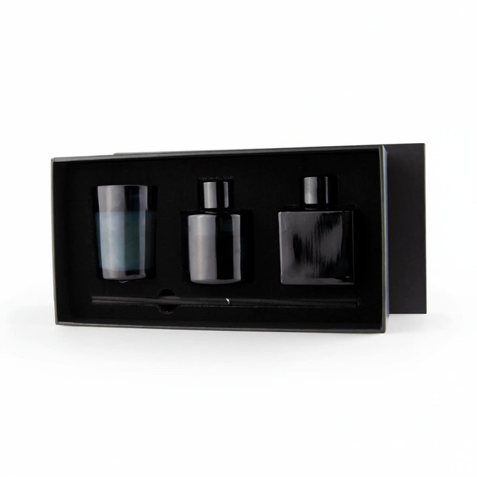 Aroma diffuser and candle gift box featuring a blue candle, two black diffusers, and a stir stick in a sleek black box.