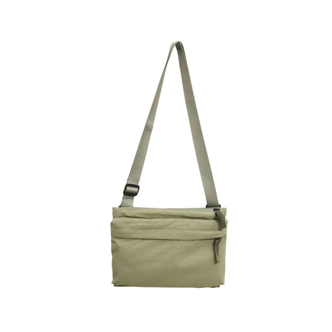 A lightweight crossbody bag in a muted beige colour with an adjustable strap and a zippered front pocket.