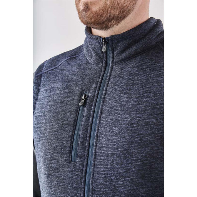 A close-up of a men's full zip fleece vest in navy blue, featuring a zippered pocket and a high collar.
