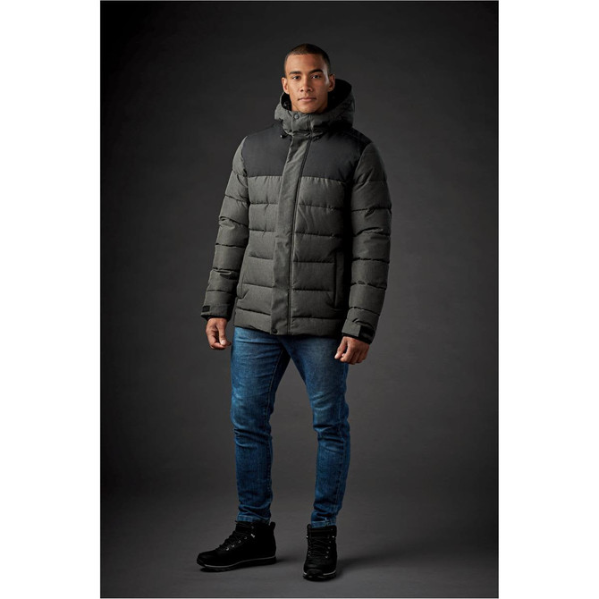A men's parka in dark grey with a hood, featuring a puffer design, displayed on a model against a dark background.