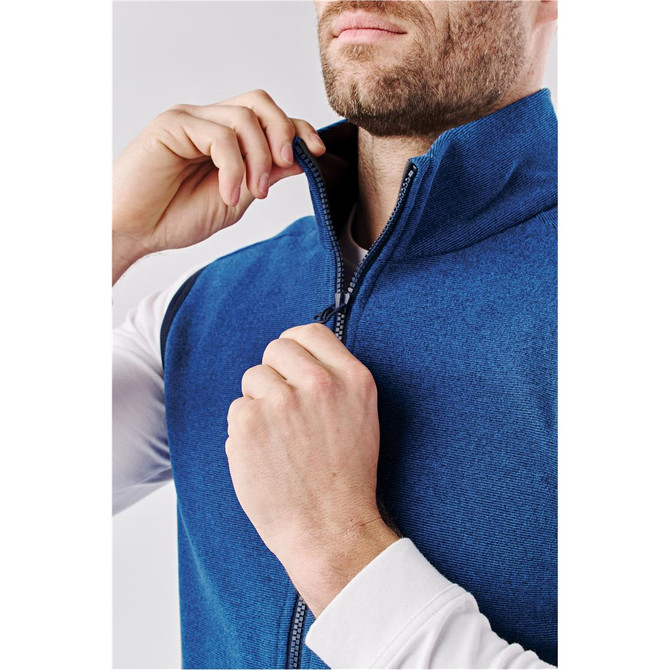 A blue men's vest with a high collar, featuring a zippered front closure and a model adjusting the zipper.