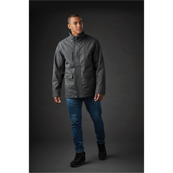 A man's dark grey jacket with a zip front and pockets, paired with blue jeans and black shoes.