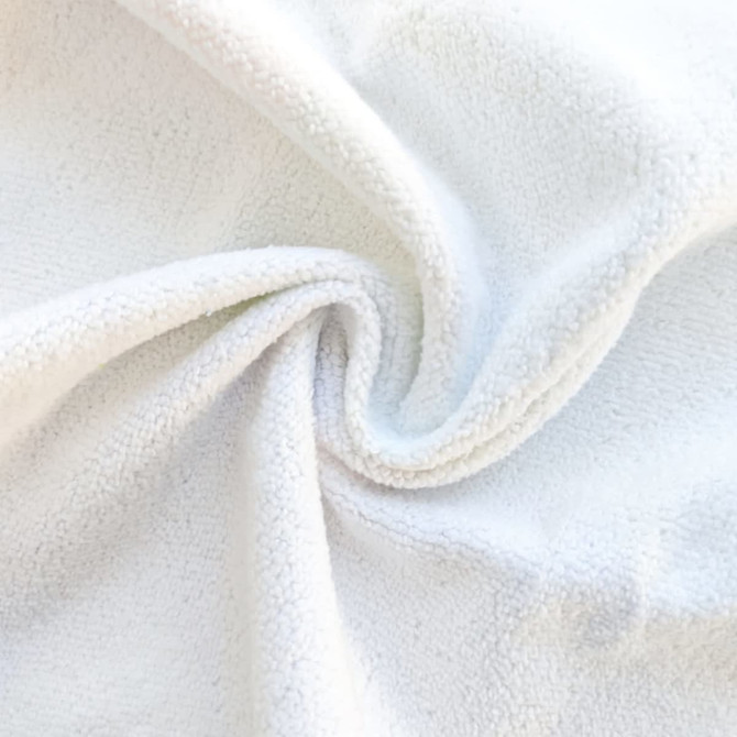 A white microfibre towel with a soft, textured surface, showcasing its spiral design.