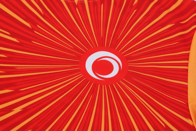 A long-sleeved shirt featuring a vibrant red and yellow design with a circular logo at the centre.
