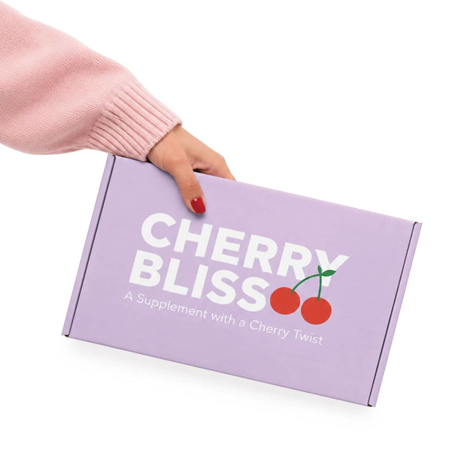 A hand holding a purple box with a locking lid, featuring a logo and cherry graphic.