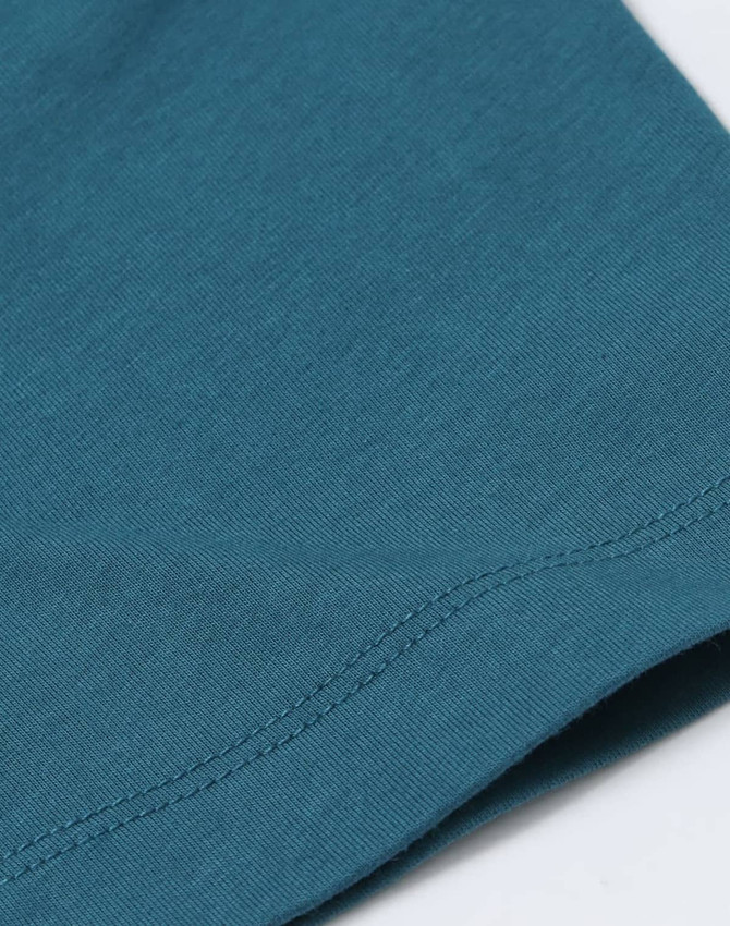A close-up view of a teal premium cotton T-shirt, showcasing the fabric texture and stitching details.