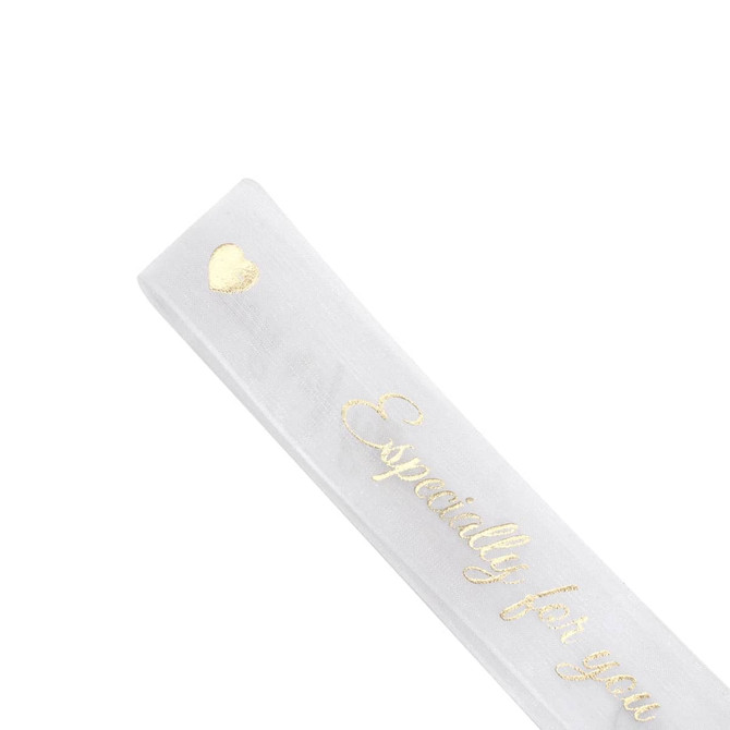 A sheer white organza ribbon featuring gold lettering and embellishments. Includes a heart design.