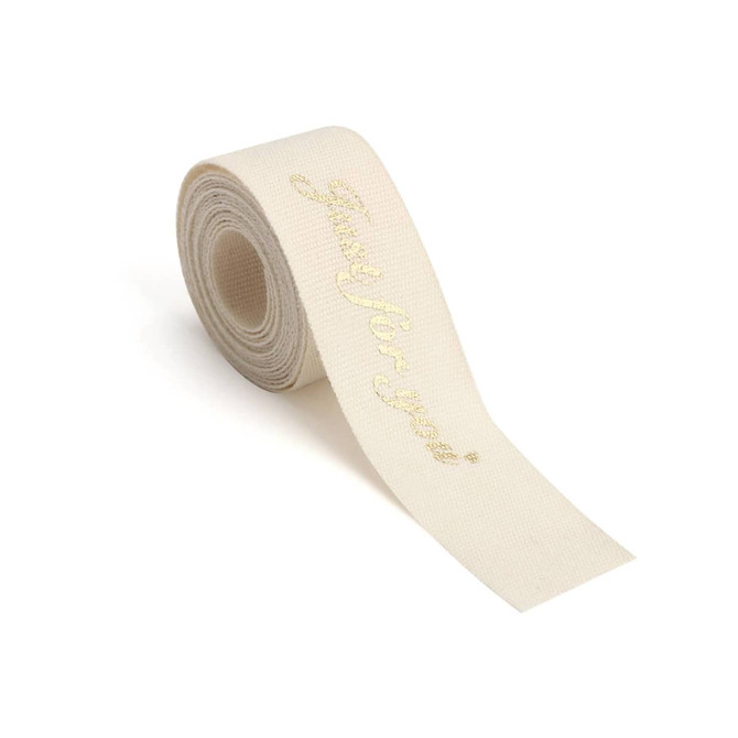 A roll of cream-coloured cotton ribbon featuring a gold hot-stamped message. It has a branding logo.