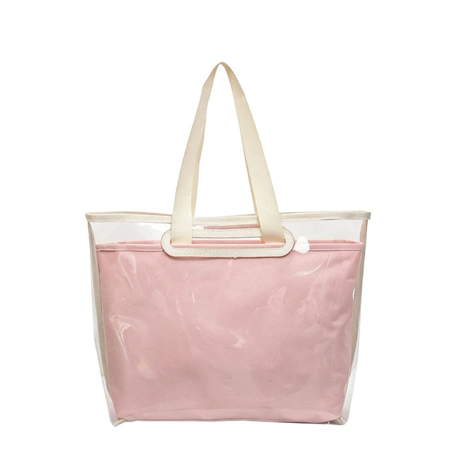 A pink tote bag with a detachable clear PVC cover and cream handles. It features a simple design and a branded logo.