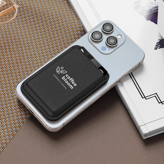 A black PU foldable magnetic card holder with a phone stand attached to a light-coloured smartphone.