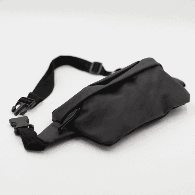A black Boston Bag with an adjustable strap and a zippered pocket, featuring a simple and sleek design.