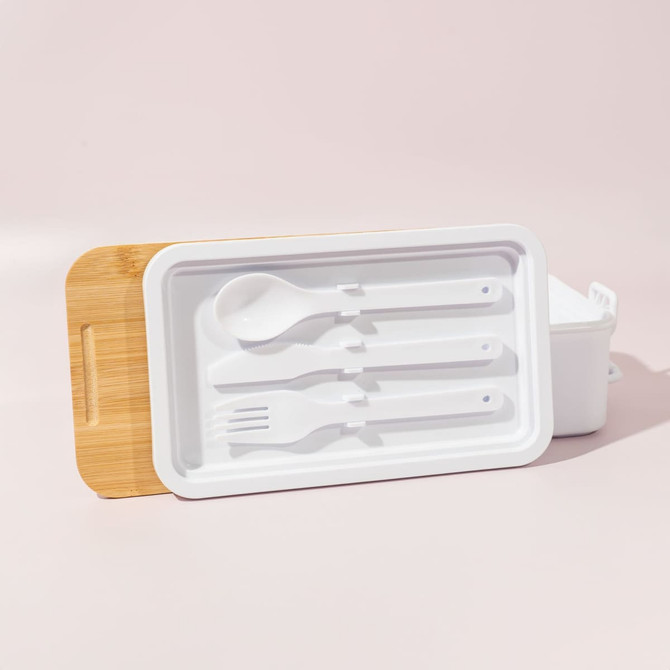 A double stack lunch box in white with a bamboo lid, featuring a spoon, fork, and knife included.