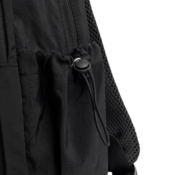 A close-up of a black backpack featuring a drawstring pocket and textured straps. The backpack has a logo.
