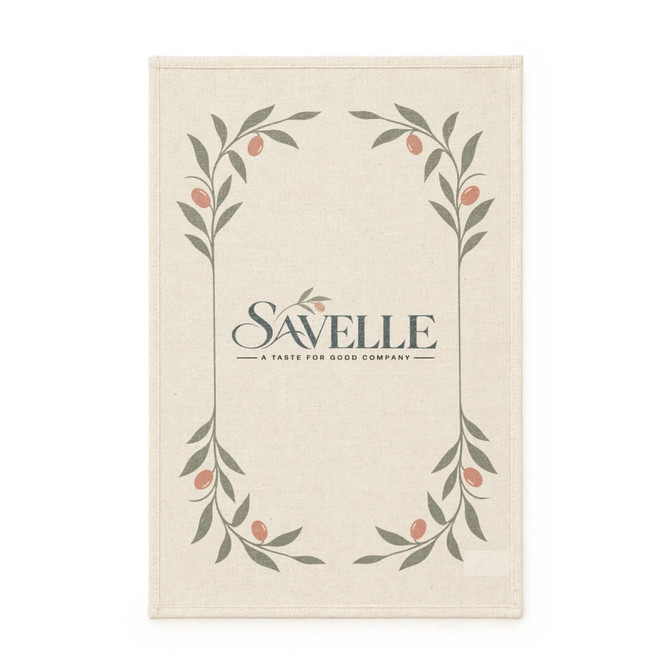 A cream-coloured tea towel featuring a floral design with green leaves and small pink accents, with a logo at the centre.