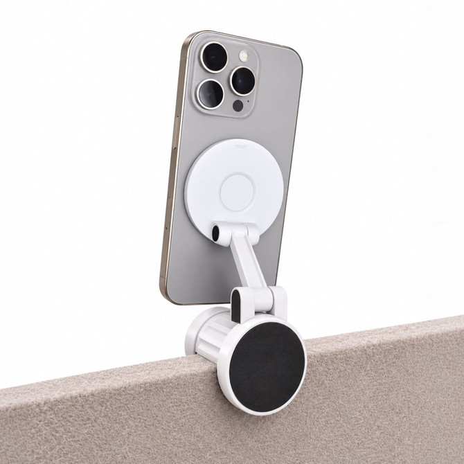 A white Tutor Maglock phone holder attached to the edge of a surface, holding a smartphone securely in place.