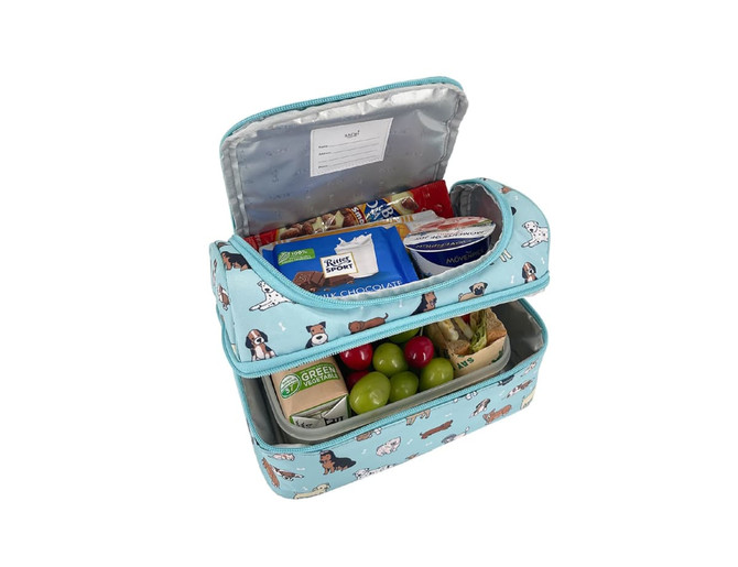 A double-decker lunch bag in light blue featuring a dog pattern, filled with snacks and a drink carton.