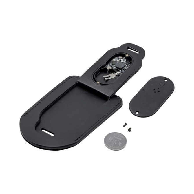 A black luggage tag with a detachable cover revealing internal components, alongside a coin and screws.