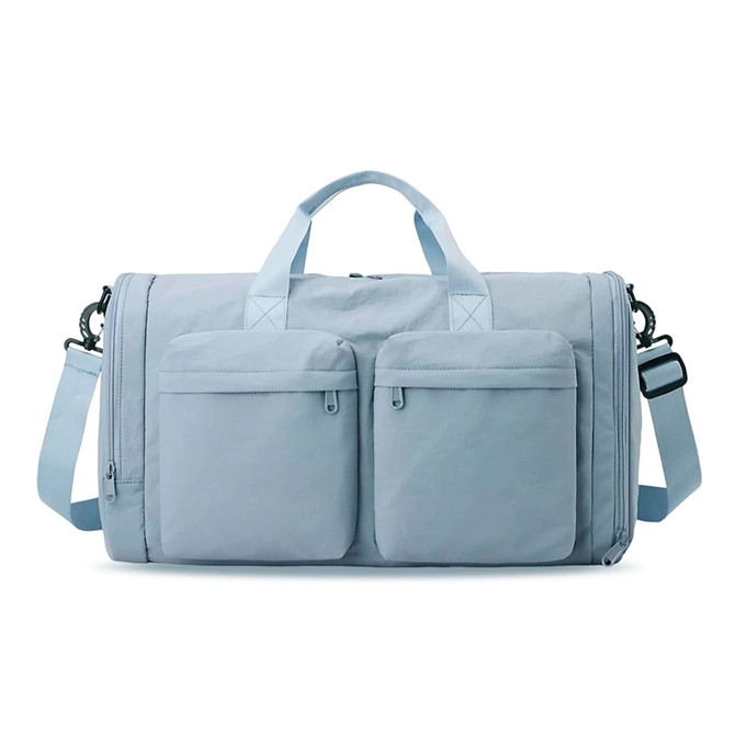 A foldable travel duffle bag in light blue with two front pockets and a detachable shoulder strap.