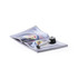 A magnifier in silver and black rests on an open magazine, highlighting its pages.