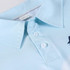 A light blue polyester spandex fishing polo shirt with a collar and buttons, featuring a logo.