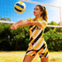 A woman in a vibrant yellow and black striped button-up shirt, featuring a volleyball design, standing on a volleyball court.