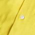 A close-up of a yellow fabric featuring a white button, part of a shirt. The texture is visible in the material.