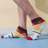 Ankle socks featuring a custom pattern in blue, yellow, red, and brown, with branding visible on the design.