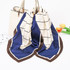A silk chiffon scarf featuring a blue and cream geometric pattern, displayed draped over a handbag.