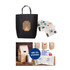 A large black paper boutique bag with handles and various stickers displayed beside it.