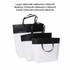Three paper bags in black and white, featuring a large, medium, and small size with handles, and a logo on the large bag.