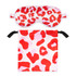 A satin sleep mask in red and pink leopard print, accompanied by a matching drawstring pouch.