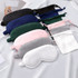 A collection of satin sleep masks in various colours, including navy, green, pink, grey, and white, with packaging.