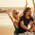A blue disposable PVC wristband is worn by a woman on the beach while enjoying time with friends.