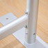 A silver metal frame with a base, featuring screws and a joint for stability, set against a wooden surface.